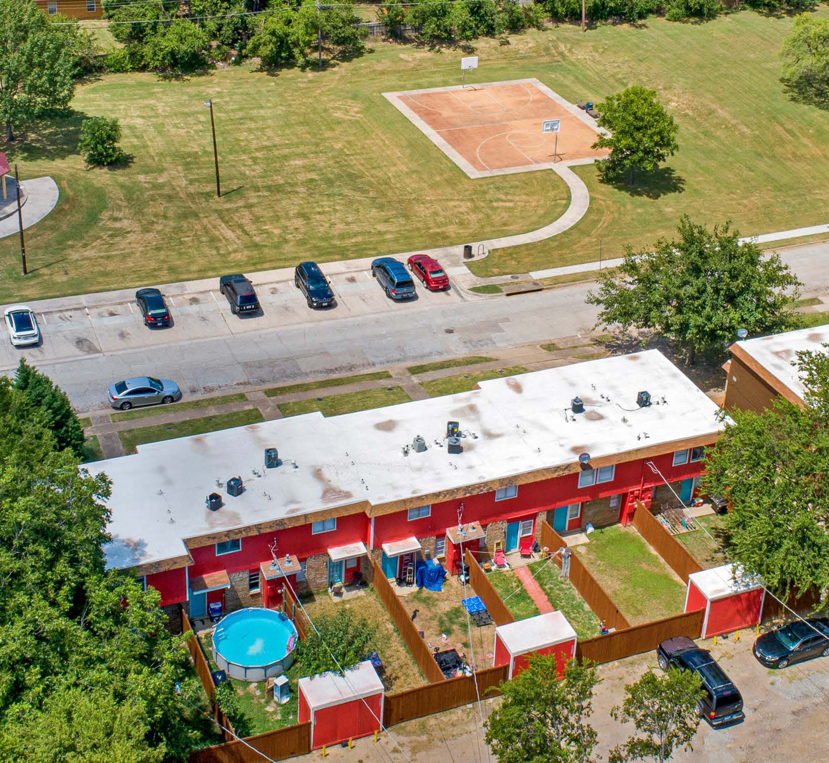 Aerial view of El Paso on the Park townhomes directly across the street from the park, its playground, and basketball court
