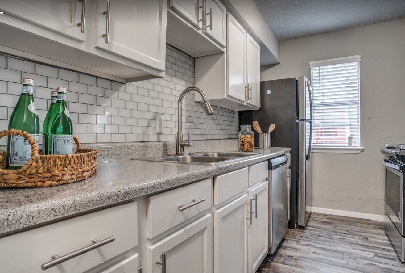 Renovated kitchen with white cabinets, subway tile, and stainless appliances